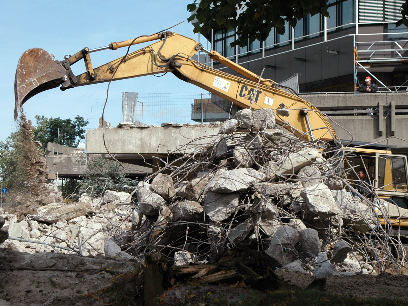 Ein Bagger reißt den Beton vor dem MZH Gebäude der Universität Bremen auf.