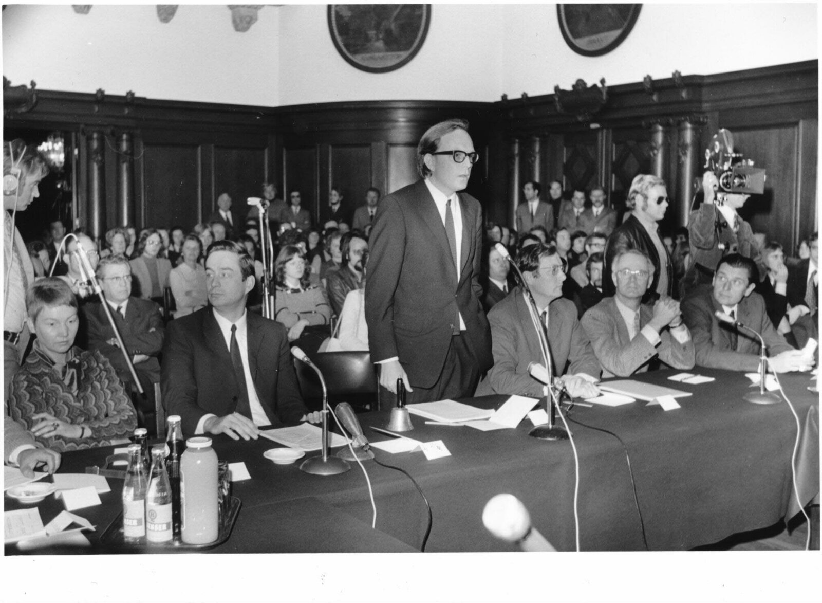 Gründungsrektor Dr. Thomas von der Vring (stehend) hält seine Rede bei der feierlichen Eröffnung der Universität im Festsaal des Bremer Rathauses. Links von ihm der Kanzler der Universität Dr. Hans-Heinrich Maaß und Dr. Heide Gerstenberger, rechts drei we