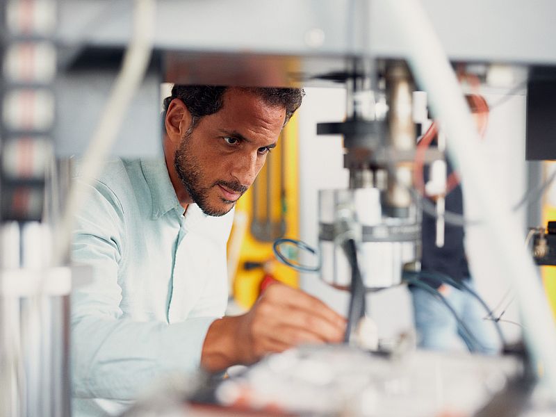 Ein Wissenschaftler arbeitet an einem technischem Gerät